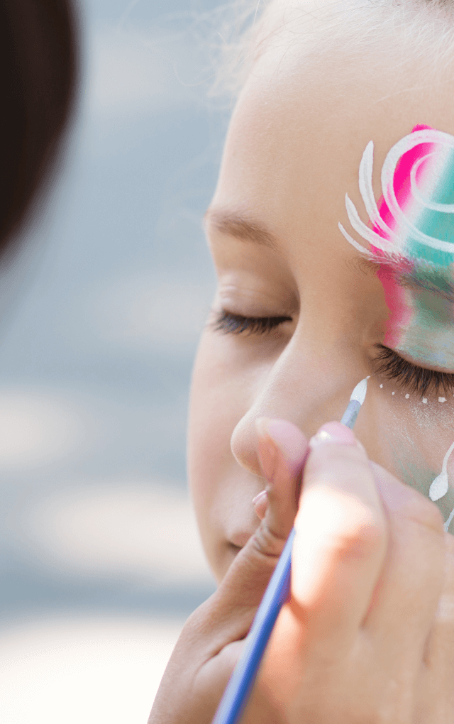 Girl getting face painted at a festival